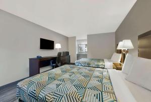 Habitación de hotel con 2 camas y escritorio en Motel 6 McDonough, GA, en McDonough