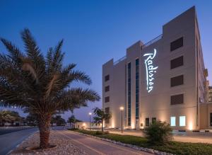 a large building with a large clock on it at Radisson Resort Ras Al Khaimah Marjan Island in Ras al Khaimah