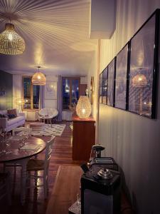 a living room with tables and chairs and a living room at "Le Noeud vert" Appartement sur le thème de Nevers, 65 m2 en coeur de ville, parking à 200M avec accès inclus à salle de sport de 2000m2, Sauna & Hammam, by PRIMO C0NCIERGERIE in Nevers