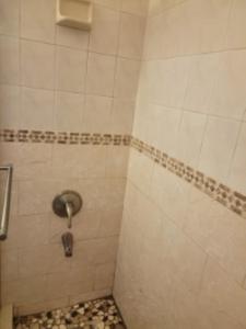 a bathroom with a shower with a tiled floor at Welcome Heart and Reliable Heart Vacation Houses in Miami +7 photos
