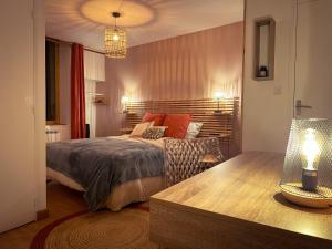 a bedroom with a bed and a table with a lamp at "Le Noeud vert" Appartement sur le thème de Nevers, 65 m2 en coeur de ville, parking à 200M avec accès inclus à salle de sport de 2000m2, Sauna & Hammam, by PRIMO C0NCIERGERIE in Nevers