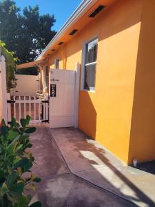 a yellow house with a garage and a window at Welcome Heart and Reliable Heart Vacation Houses in Miami