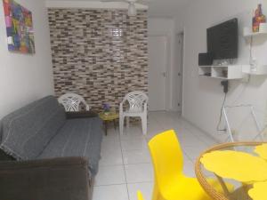 a living room with a couch and a table and chairs at AP VOG PRAIA ILHÉUS BA, Ar Condicionado nos 2 quartos! in Ilhéus