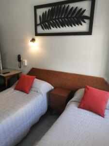 two beds in a hotel room with red pillows at Suite Confortable en Palermo Omega in Buenos Aires +16 photos