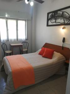 - une chambre avec un grand lit et 2 oreillers rouges dans l'établissement Suite Confortable en Palermo Omega, à Buenos Aires