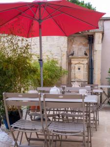 un parapluie rouge assis sur une table avec des chaises dans l'établissement Clos Saint Martin, à Caen