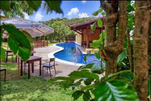 a resort with a swimming pool and a house at Sol da Pipa Flats Bosque da Praia in Pipa