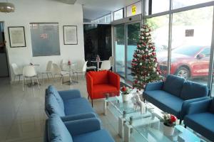 a living room with blue couches and a christmas tree at City Caribbean Hotel Boutique in Santo Domingo