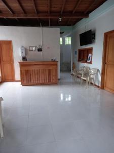 a large room with white tiled floor and a courtroom at Hostal Zurymar Capurganá in Capurganá