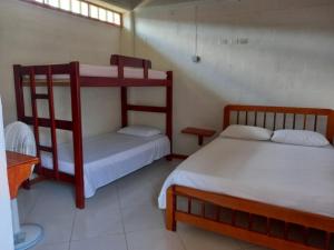 a room with two bunk beds and a table at Hostal Zurymar Capurganá in Capurganá