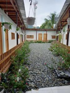 a courtyard of a house with rocks and flowers at Hostal Zurymar Capurganá in Capurganá