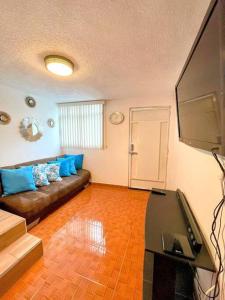 sala de estar con sofá y TV de pantalla plana en DEPTO FRENTE AL AUTODROMO HMNOS A 10 MIN CAMINANDO en Ciudad de México