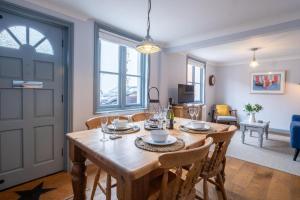 uma sala de jantar com uma mesa de madeira e cadeiras em Sailmaker's Cottage em Lymington