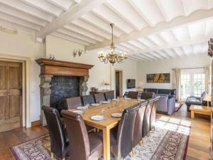 une salle à manger avec une table, des chaises et une cheminée dans l'établissement Luxurious Holiday Home in erezee with Jacuzzi, à Érezée