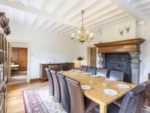 une salle à manger avec une table, des chaises et une cheminée dans l'établissement Luxurious Holiday Home in erezee with Jacuzzi, à Érezée