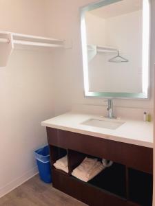a bathroom with a sink and a mirror at Extended Studio Suites in San Jose