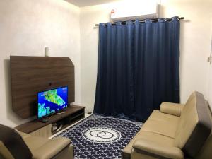uma sala de estar com um sofá e uma televisão em CASA IDAMAN - Islamic Homez em Malaca
