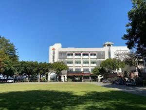 a large building with a lawn in front of it at Zhi Da Craft Service Guest House in Caotun