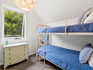 1 Schlafzimmer mit 2 Etagenbetten und einem Fenster in der Unterkunft Point Roadknight Paradise Villa 6 in Anglesea