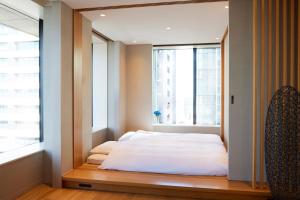 uma cama num quarto com uma janela em Ascott Marunouchi Tokyo em Tóquio