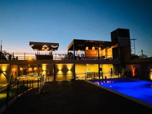 a view of a building with a swimming pool at night at Paraiso Natural Apart Hotel Iguazu in Puerto Iguazú