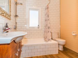 a bathroom with a tub and a sink and a toilet at The Lazy Carrot - Ohakune Holiday Home in Ohakune +19 photos