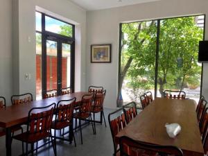 a dining room with tables and chairs and large windows at Tản Đà Lake View Ba Vì - Venue Travel in Hanoi