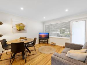 a living room with a couch and a table and a tv at Thurlow Avenue 49 Unit 1 in Nelson Bay