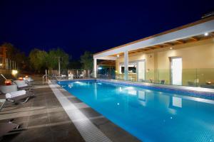 a swimming pool at night with a hotel at Asteria Studios in Potos