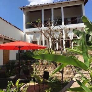 ein Gebäude mit einem roten Regenschirm, Tischen und Stühlen in der Unterkunft Terramaya Boutique Hotel in Ruinas de Copán