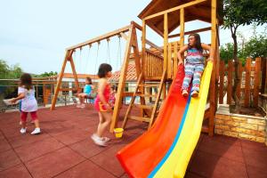 two children playing on a slide at a playground at Asteria Studios in Potos