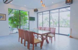 a dining room with a table and chairs and windows at Tản Đà Lake View Ba Vì - Venue Travel in Hanoi