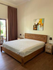 een slaapkamer met een bed en een schilderij aan de muur bij Red island villas in Banyuwangi +92 foto's