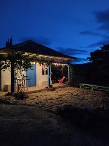 uma casa com uma porta azul e um banco à noite em El Oteo Tiny house. em Villa de Leyva