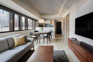 uma sala de estar com um sofá e uma mesa em Oakwood Hotel & Apartments Azabu Tokyo em Tóquio