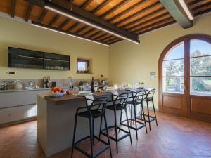 a kitchen with a long bar with stools in it at Timeless Tuscan Holiday Stay in Arezzo