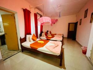 two beds in a room with red curtains at Rock Cascade Tourist Home & Cookery School in Polonnaruwa +63 photos