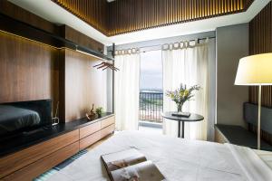 een slaapkamer met een groot bed en een groot raam bij Futura Studio-Modern Apartment near CBD BSD in Serpong