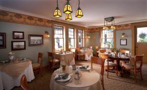 a dining room with tables and chairs and windows at 1906 Lodge in San Diego