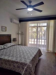 um quarto com uma cama e uma ventoinha de tecto em Las Terrenas beachfront 2 bedrooms condo with pool em Las Terrenas