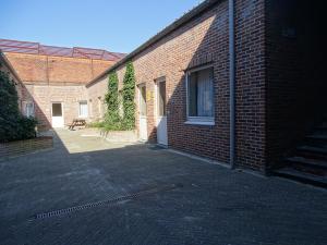 ein Backsteingebäude mit einer Terrasse und einem Fenster in der Unterkunft Condo Gardens Leuven - Budget Studio Twin in Löwen