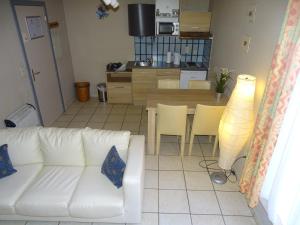 ein Wohnzimmer mit einem weißen Sofa und einer Küche in der Unterkunft Condo Gardens Leuven - Budget Studio Twin in Löwen