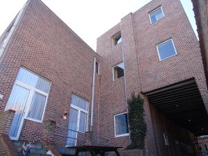 - un bâtiment en briques rouges avec un grand garage dans l'établissement Condo Gardens Leuven - Budget Studio Twin, à Louvain