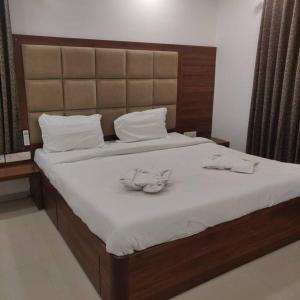 a bedroom with a large bed with white sheets and a headboard at Chillx comfort stay 2bhk luxury apt in Arpora