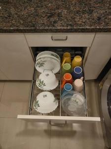 a drawer in a kitchen with plates and bowls at Chillx comfort stay 2bhk luxury apt in Arpora