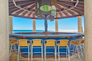 a bar with chairs and a table with the ocean in the background at Shores of Panama III in Panama City Beach