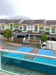 a swimming pool in front of some houses at Azzalea Terrace House @ Golden Hills Night Market Cameron Highlands in Brinchang