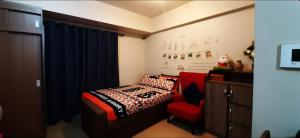 um quarto com uma cama e uma cadeira vermelha em 150 Newport City Condo - near NAIA T3 AIRPORT MANILA em Manila