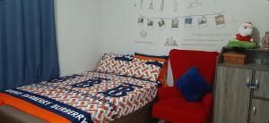 um quarto com uma cama e uma cadeira vermelha em 150 Newport City Condo - near NAIA T3 AIRPORT MANILA em Manila