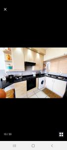 a kitchen with white cabinets and a stove top oven at Rockview Holiday Beach Apartment in Hibberdene
